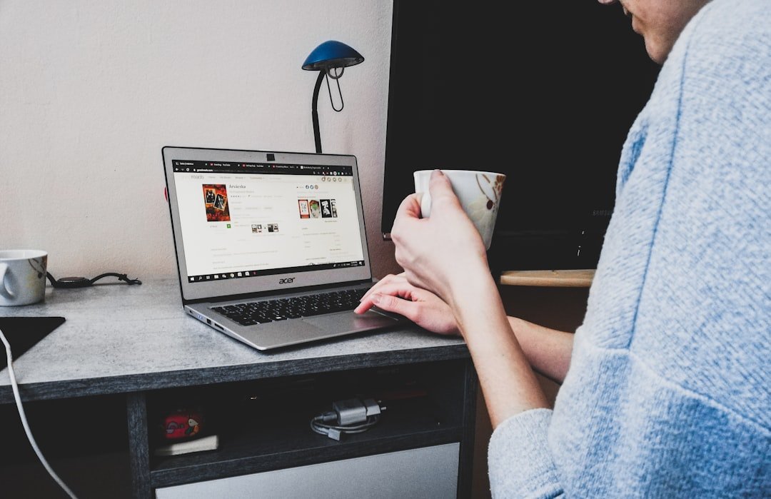 Mujer trabajando desde casa con laptop revisando mensajes